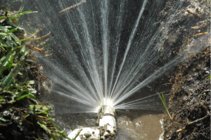 Heavily damaged sprinkler pipe sprays in wide hard